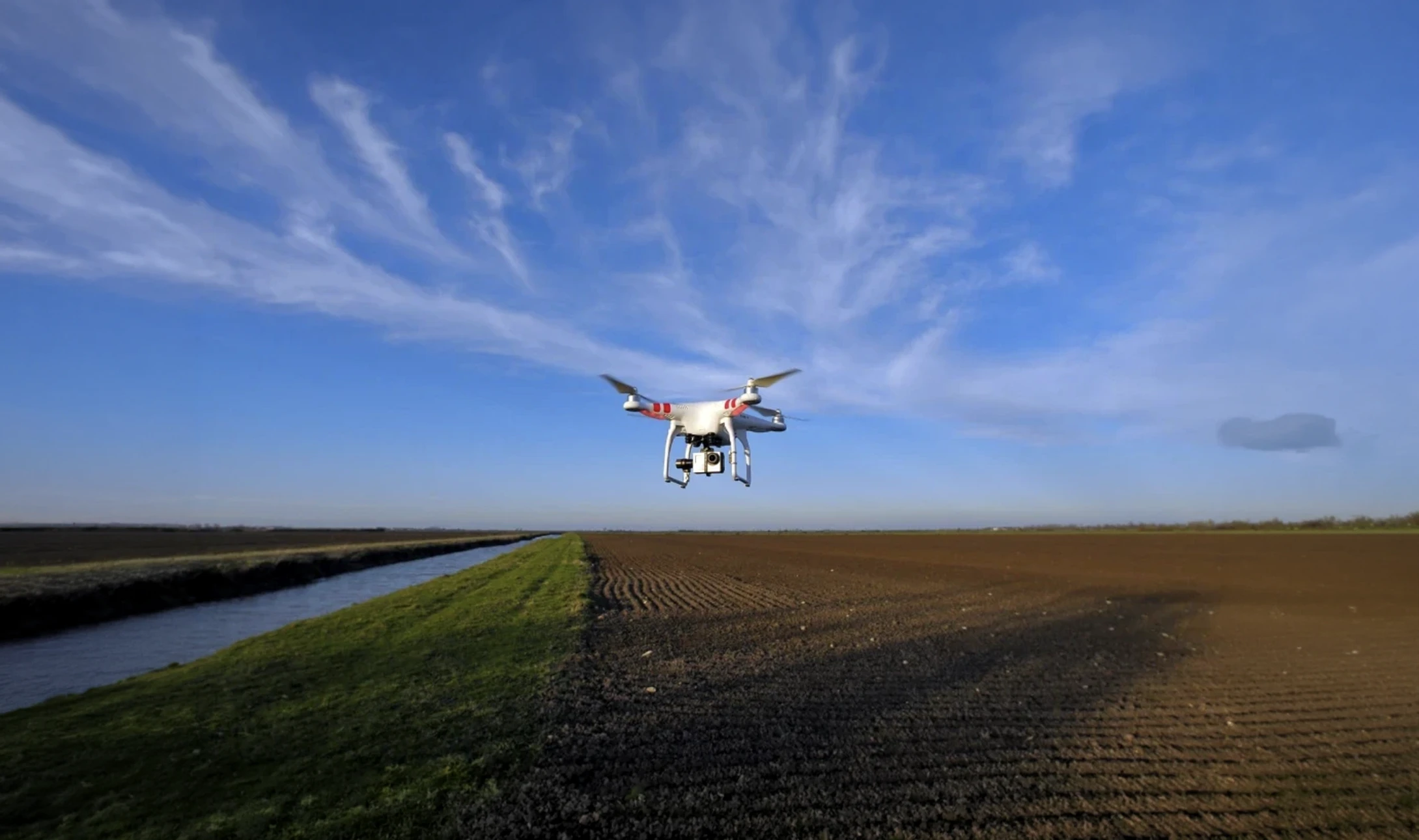Deux agents d'entretien en uniformes blancs et roses nettoient les vitres d'un immeuble moderne depuis l'extérieur