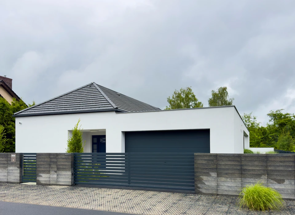 Façade d'une maison provençale avec murs ocre et volets bleus ouverts